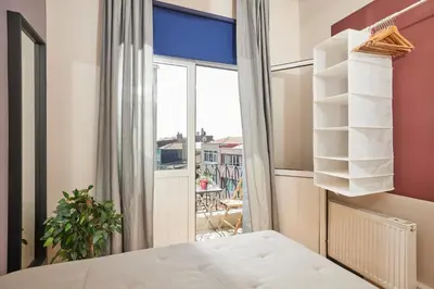 a bedroom with a bed and a large window at Comfortable 2BR Flat in Nişantaşı Near Metro in Istanbul