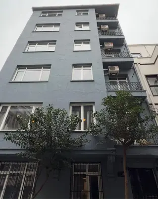 a tall gray building with trees in front of it at Modern 2BR in Nisantasi Area Balconies & AC in Istanbul