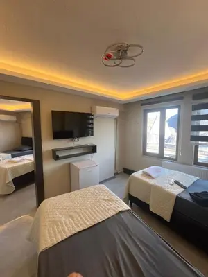 a hotel room with two beds and a television at rema house in Gemlik