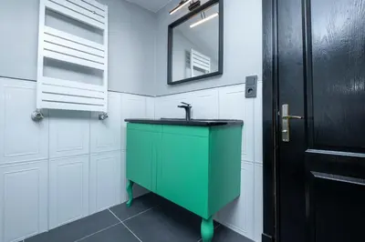 a bathroom with a green sink and white cabinets at Central 4-Bedroom House with Private Terrace and 2 Bathrooms in Istanbul