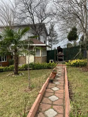 a garden with a stone path in front of a house at Ciğ Bungalov Airport in Arnavutköy
