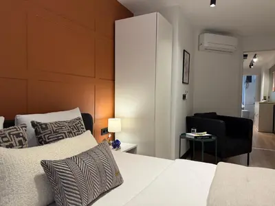 a bedroom with a white bed and a black chair at Stunning Combo Flat in Nisantasi in Istanbul