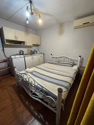 a large bed in a room with a kitchen at Naila ahmadreza in Istanbul