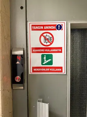 a sign on the wall of a bathroom with a warning sign at Bright & Modern 2-Bedroom Flat Near Metro in Istanbul