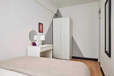 a white bedroom with a bed and a mirror at Stylish 2BR in Central Istanbul 3-Min to Metro in Istanbul