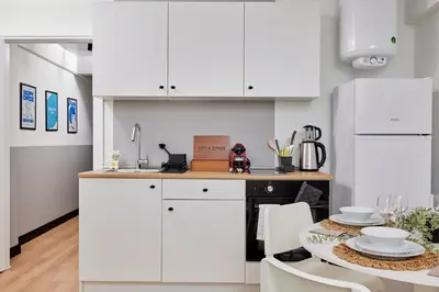 a kitchen with white cabinets and a table at Stylish 2BR in Central Istanbul 3-Min to Metro in Istanbul