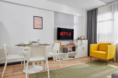 a living room with a table and a yellow chair at Stylish 2BR in Central Istanbul 3-Min to Metro in Istanbul