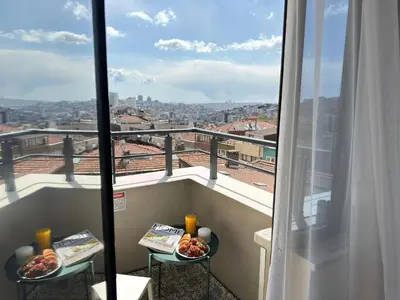 a balcony with two plates of food and a view of a city at Superb Location 3 Min to Metro AC Elevator in Istanbul