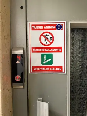 a sign on the wall of a bathroom with a warning sign at Superb Location 3 Min to Metro AC Elevator in Istanbul