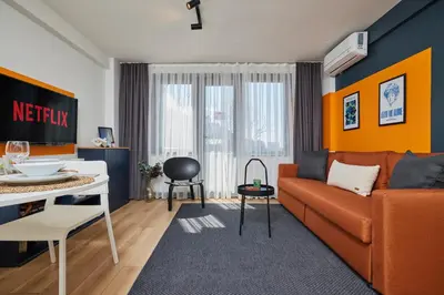 a living room with an orange couch and a table at Superb Location 3 Min to Metro AC Elevator in Istanbul