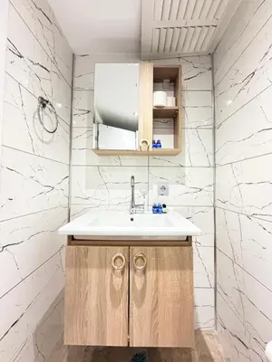 a bathroom with a sink and white marble walls at The Blue Mansion Modern Rooms in Istanbul