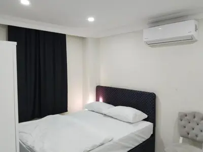 a bedroom with a white bed with a black headboard at White garden in Tuzla