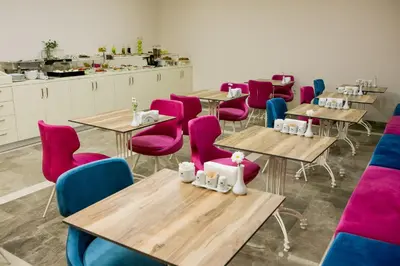 a room with tables and chairs with pink chairs at Babil Hotel in Istanbul