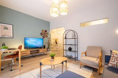 a living room with a tv and a chair and a table at Fully Renovated 2BR Flat in Center of Moda in Istanbul