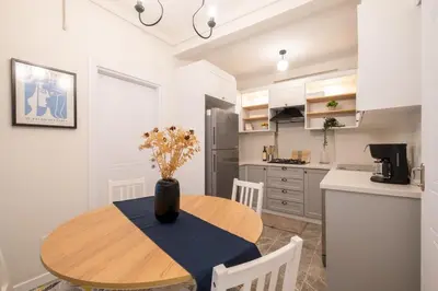 a kitchen with a wooden table and a table and chairs at Fully Renovated 2BR Flat in Center of Moda in Istanbul