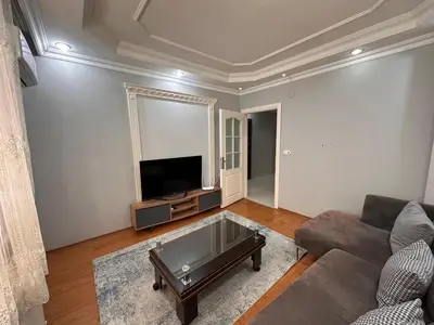 a living room with a couch and a flat screen tv at Metroya 3 dakima uzaklıkta merkezi konumda in Istanbul