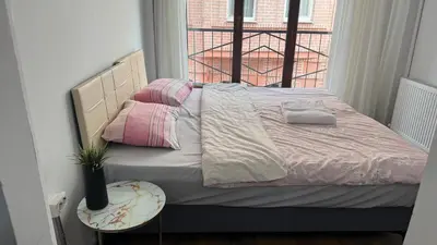 a bed with pink and white sheets and a window at Balat in Istanbul