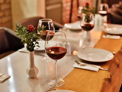 a table with two glasses of wine and a vase of flowers at Sanat Boutique Hotel Pera in Istanbul