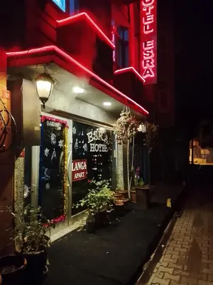 a store with a neon sign on the side of a street at İSTANBUL ESRA Hotel in Istanbul