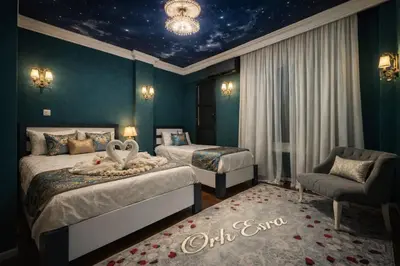 a hotel room with two beds and a chair at İSTANBUL ESRA Hotel in Istanbul