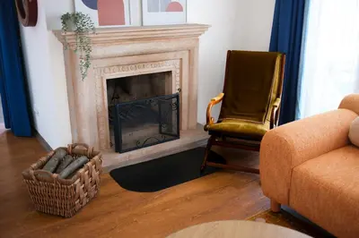 a living room with a fireplace and a chair at Terrazzo Sapanca - Isıtmalı Havuzlu Villa Verde in Sapanca
