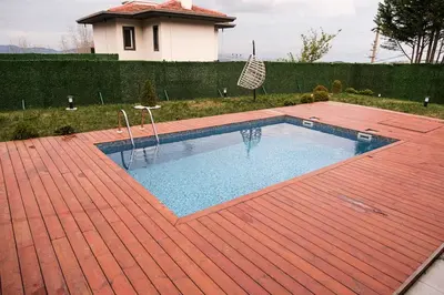 a swimming pool on a red tile floor with a house at Terrazzo Sapanca - Isıtmalı Havuzlu Villa Sole in Sapanca