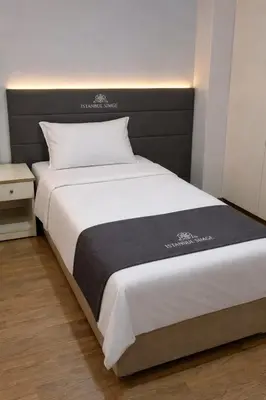a large bed with a black headboard in a room at İstanbul SİMGE hotel in Istanbul