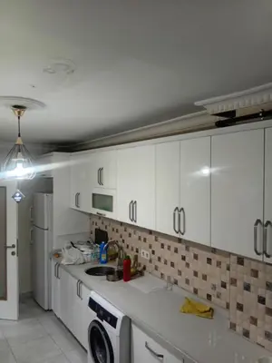 a kitchen with white cabinets and a washing machine at Sağlam Apartments 1 in Istanbul