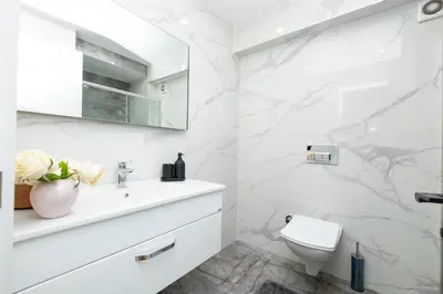 a white bathroom with a toilet and a sink at Sea View Two-Bedroom Suite in Managed Residence - Parking and Elevator in Istanbul