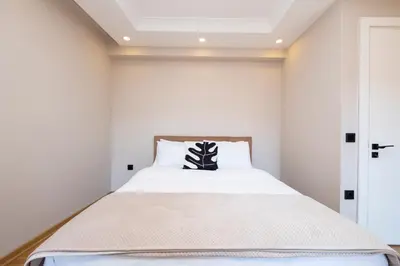 a bedroom with a bed with a black and white pillow at Sea View Two-Bedroom Suite in Managed Residence - Parking and Elevator in Istanbul
