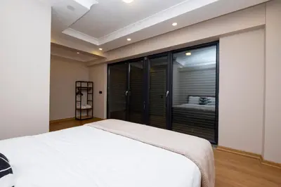 a bedroom with a white bed and a large window at Sea View Two-Bedroom Suite in Managed Residence - Parking and Elevator in Istanbul