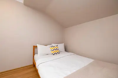 a small white bedroom with a bed with a pillow at Sea View Two-Bedroom Suite in Managed Residence - Parking and Elevator in Istanbul