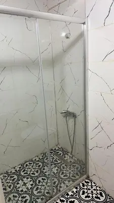 a shower with a glass door and a tile floor at balatlifesuites in Istanbul