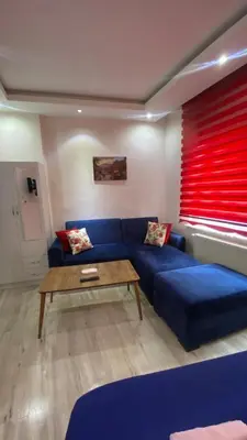 a living room with a blue couch and a wooden table at Taksim city suites in Istanbul