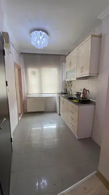 a kitchen with white cabinets and a chandelier at Taksim city suites in Istanbul