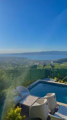 a swimming pool with chairs and a view of the countryside at Sapanca Liva Bungalov in Sapanca