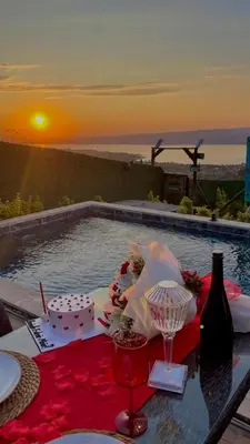 a table with a cake and a sunset in the background at Sapanca Liva Bungalov in Sapanca