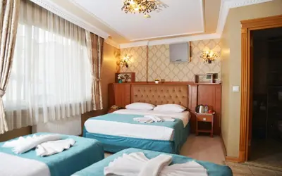 a hotel room with two beds and a window at Old City Viva Hotel in Istanbul
