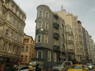 a tall building on a city street with cars at Taksim Armoni Hotel in Istanbul