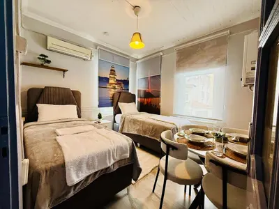 a hotel room with two beds and a table and a dining room at Cozy yellow home in Istanbul