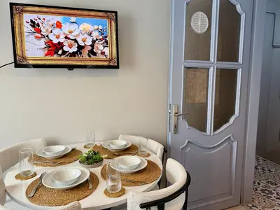 a dining room table with a painting on the wall at Cozy yellow home in Istanbul
