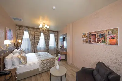 a bedroom with a large bed and a couch at Perapolis Hotel in Istanbul