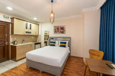 a bedroom with a bed and a desk and a kitchen at Opêra house taksim in Istanbul