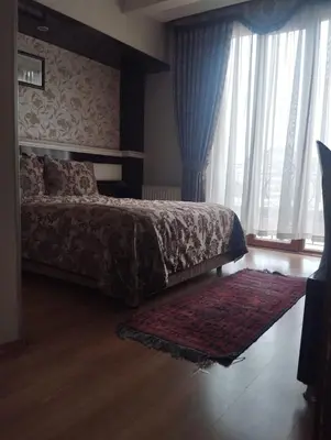 a bedroom with a bed with a rug and a window at ESEN PALAS otel in Istanbul