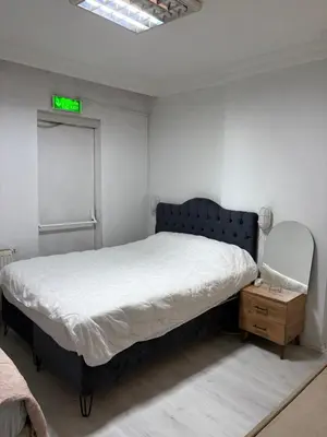a bedroom with a bed and a nightstand with a green clock at Üsküdar Sahil Konaklama in Istanbul