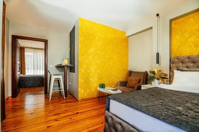 a hotel room with a bed and a yellow wall at Stories Of Galata in Istanbul