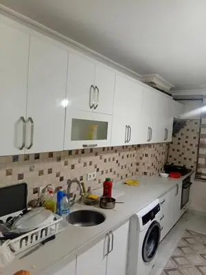 a kitchen with white cabinets and a sink and a washing machine at Sağlam Apartments in Istanbul