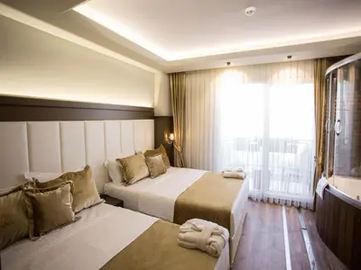 a hotel room with two beds and a window at Bonne Sante Hotel in Istanbul