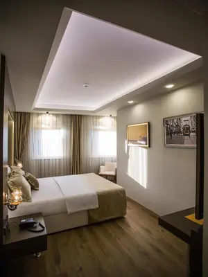 a bedroom with a large bed with a large white ceiling at Bonne Sante Hotel in Istanbul