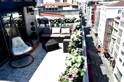 a balcony with couches and flowers on a building at Bonne Sante Hotel in Istanbul